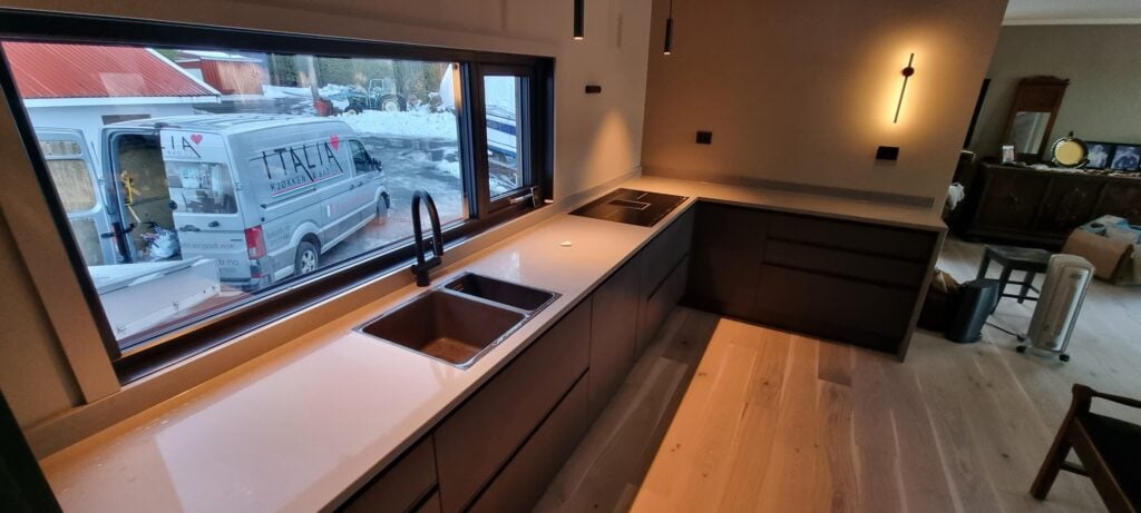 Moderne kjøkken i nyoppusset hjem med stort vindu og minimalistisk design.