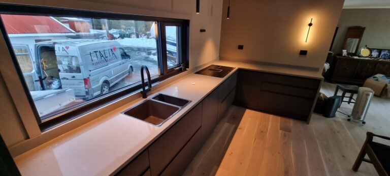 Moderne kjøkken i nyoppusset hjem med stort vindu og minimalistisk design.